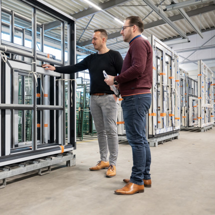 Ploeg zakelijk adviseurs bij een kozijn in stelling