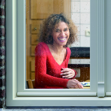 Vrouw zit achter kunststof kozijnen